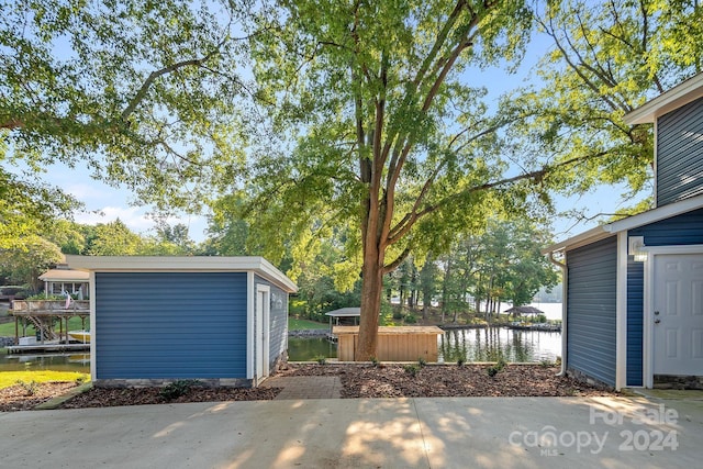 view of patio with an outbuilding and a water view