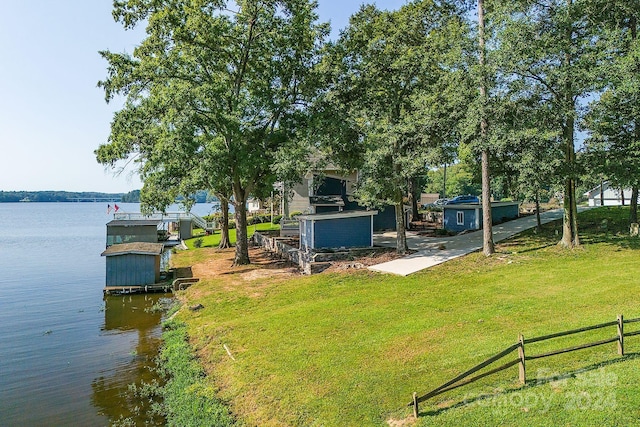 view of dock featuring a water view and a yard