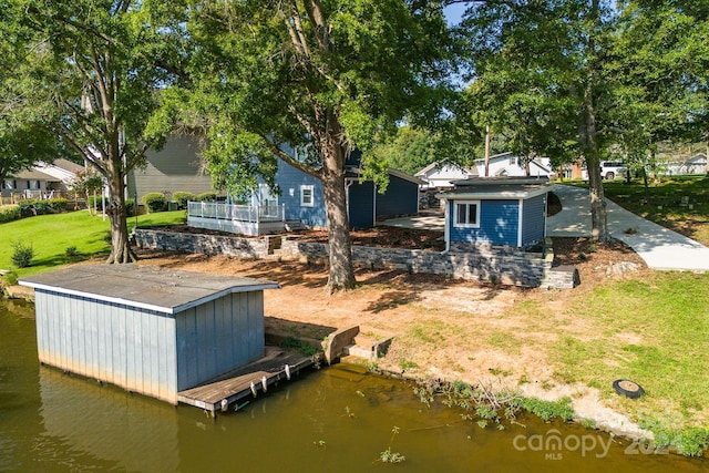 dock area with a water view and a lawn