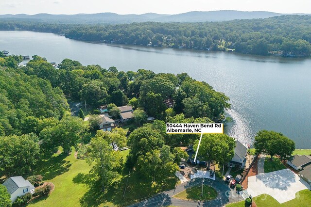 drone / aerial view with a forest view and a water view