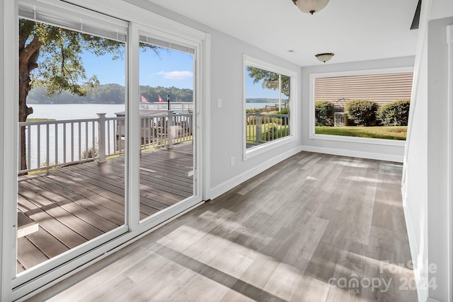 unfurnished sunroom featuring a healthy amount of sunlight and a water view