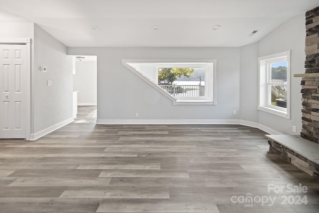 spare room with light hardwood / wood-style flooring and a stone fireplace