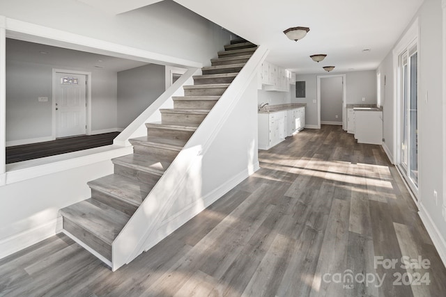 stairs featuring hardwood / wood-style floors and sink