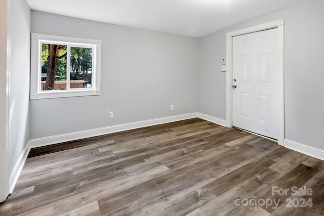 unfurnished room with baseboards and wood finished floors