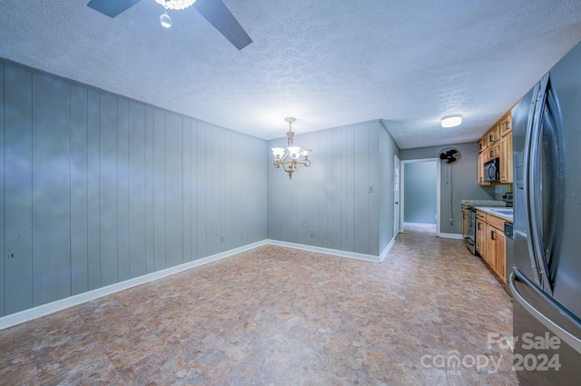 interior space featuring ceiling fan with notable chandelier and a textured ceiling