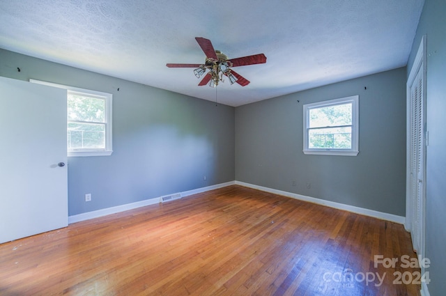 unfurnished room with a textured ceiling, ceiling fan, and hardwood / wood-style floors