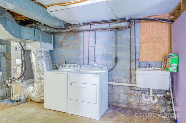 clothes washing area with washer and clothes dryer and sink