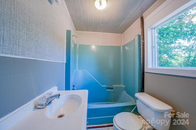 full bathroom featuring toilet, a healthy amount of sunlight, sink, and shower / tub combination