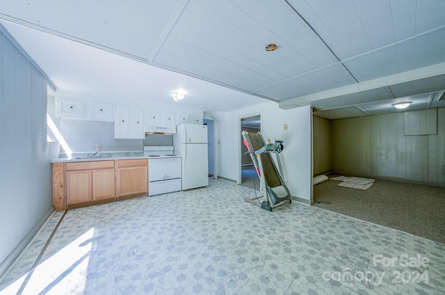 kitchen featuring light carpet, white appliances, wood walls, and sink