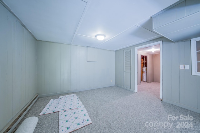 basement featuring baseboard heating, secured water heater, and carpet