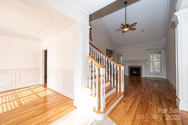 staircase with ceiling fan, crown molding, and hardwood / wood-style flooring