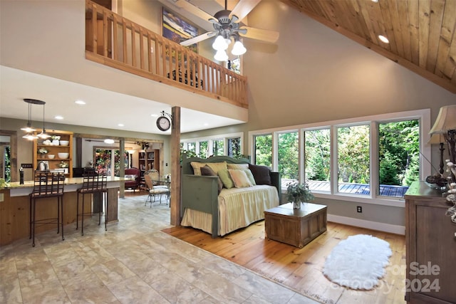 living room featuring high vaulted ceiling, light wood-type flooring, ceiling fan, and wooden ceiling