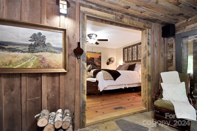 bedroom with ceiling fan, wooden walls, hardwood / wood-style floors, and wood ceiling