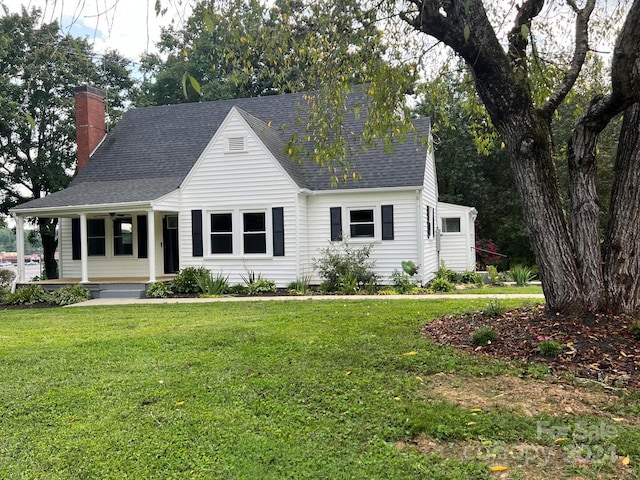 cape cod house with a front yard and a porch