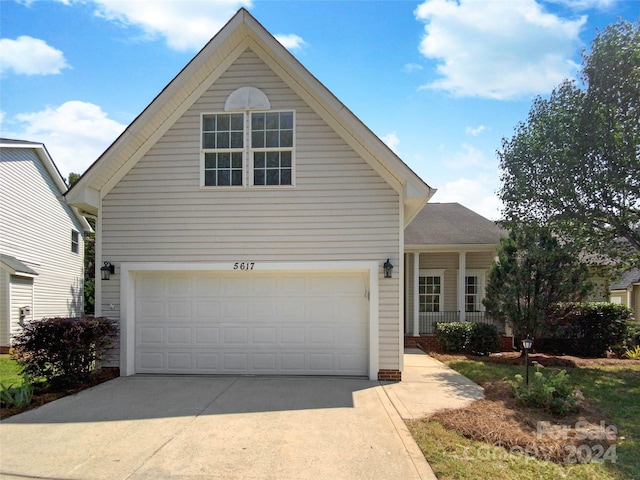 traditional home with driveway, a garage, and a porch