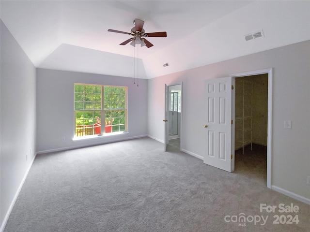 unfurnished bedroom featuring lofted ceiling, light carpet, visible vents, and baseboards