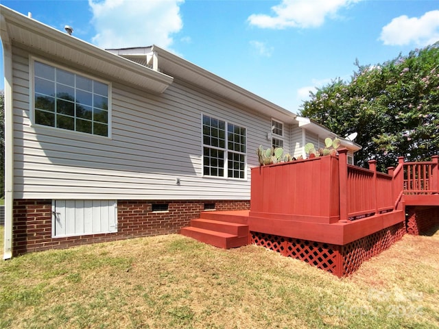 back of property featuring a yard and a wooden deck