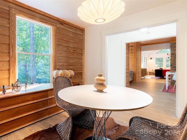 dining space with wood walls and wood-type flooring