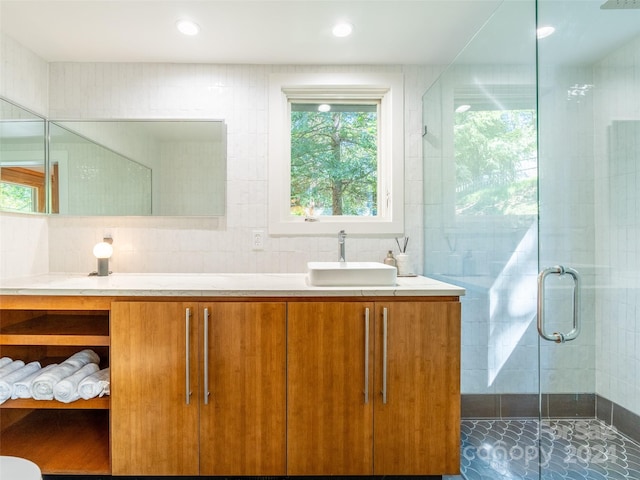 bathroom featuring vanity, tasteful backsplash, tile walls, and an enclosed shower