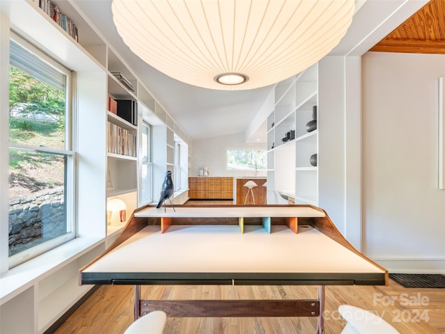 interior space with wood ceiling, lofted ceiling, a wealth of natural light, and hardwood / wood-style floors