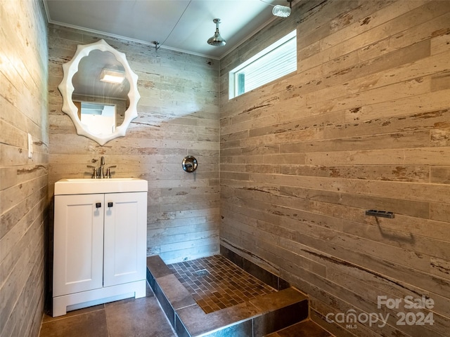 bathroom with vanity, wood walls, and walk in shower