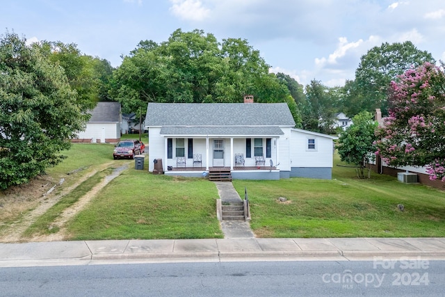 view of front of property with central AC unit, a front yard, and a porch