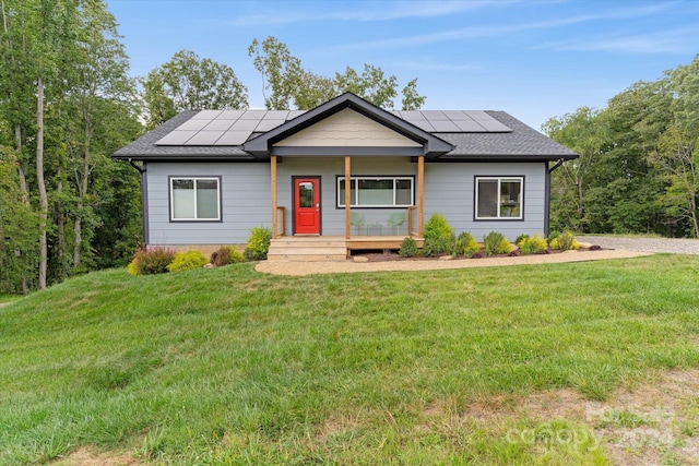 ranch-style house with covered porch, solar panels, and a front yard