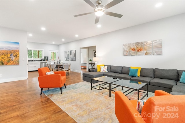 living room featuring ceiling fan and light wood-type flooring