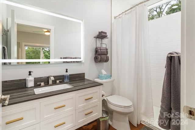 bathroom with vanity, toilet, curtained shower, and ceiling fan