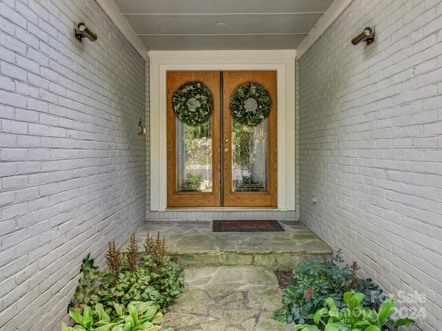 view of exterior entry with brick siding and french doors