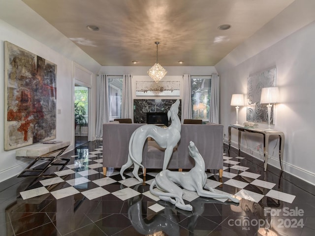 dining space with tile patterned flooring, a notable chandelier, and a premium fireplace