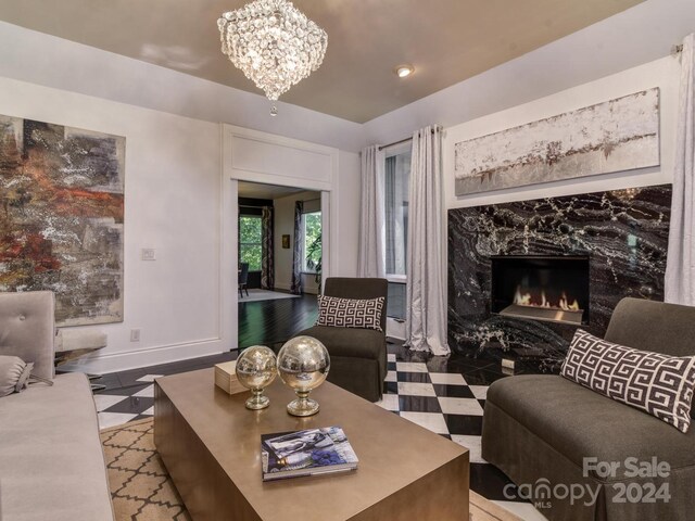 living room featuring a premium fireplace and a notable chandelier