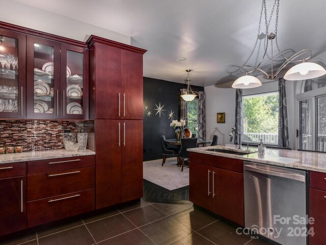 kitchen featuring dishwasher, pendant lighting, backsplash, dark tile patterned flooring, and sink