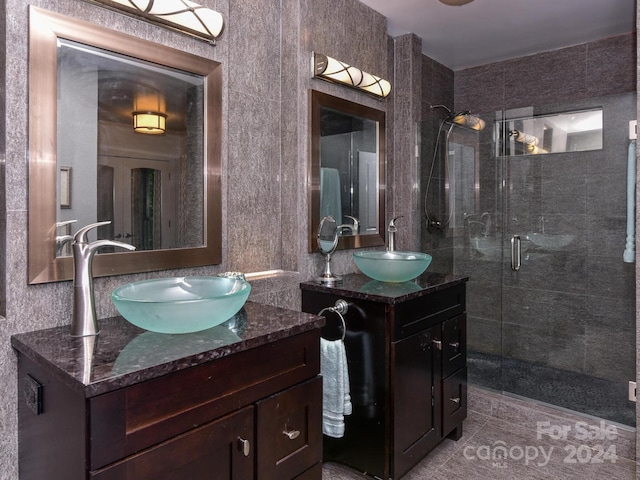 bathroom with a sink, two vanities, and a stall shower