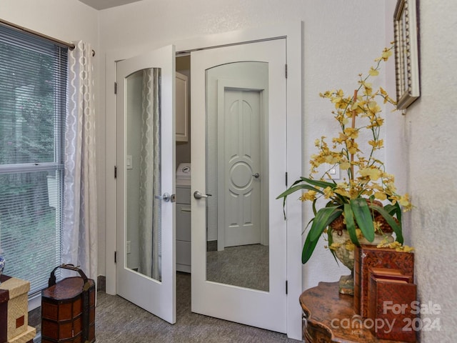 hall featuring french doors, carpet, and washer / dryer