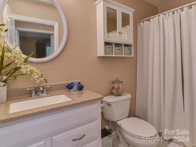 bathroom featuring vanity, toilet, and a shower with shower curtain