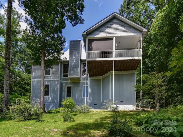 rear view of property with crawl space, a yard, a chimney, and a sunroom