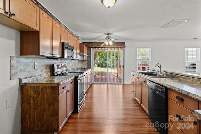 kitchen with black appliances, a healthy amount of sunlight, sink, and dark wood-type flooring