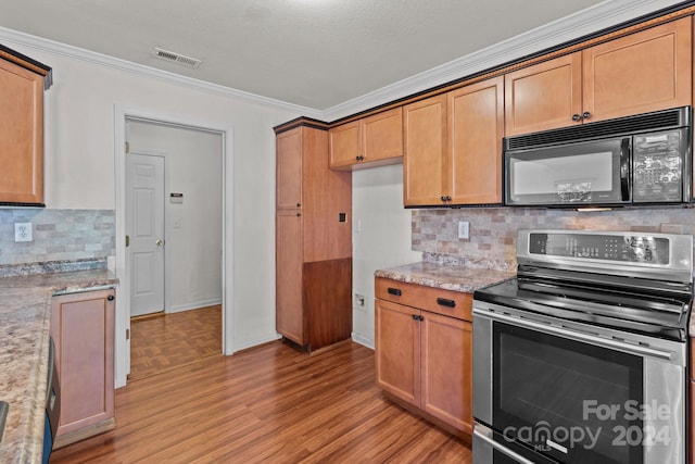 kitchen with light stone countertops, stainless steel electric range oven, crown molding, decorative backsplash, and hardwood / wood-style flooring