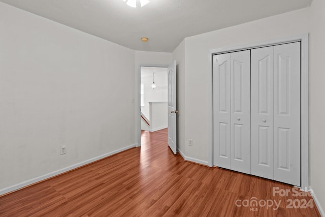 unfurnished bedroom with a closet and light hardwood / wood-style floors