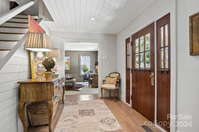 foyer featuring wooden walls and light hardwood / wood-style floors