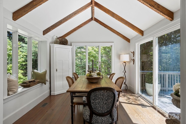 dining space featuring a wealth of natural light, dark hardwood / wood-style floors, and vaulted ceiling with beams