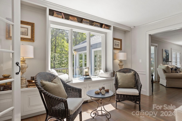 sitting room with ornamental molding and hardwood / wood-style flooring