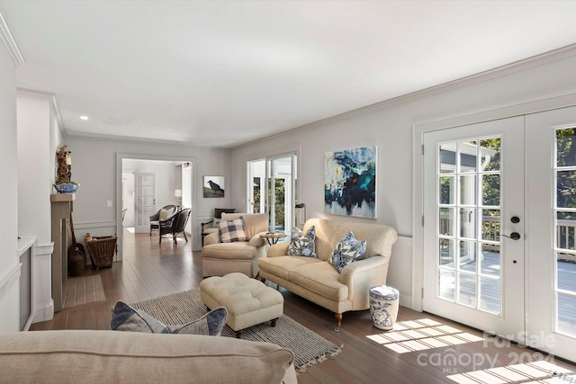 living room featuring a healthy amount of sunlight, hardwood / wood-style floors, crown molding, and french doors