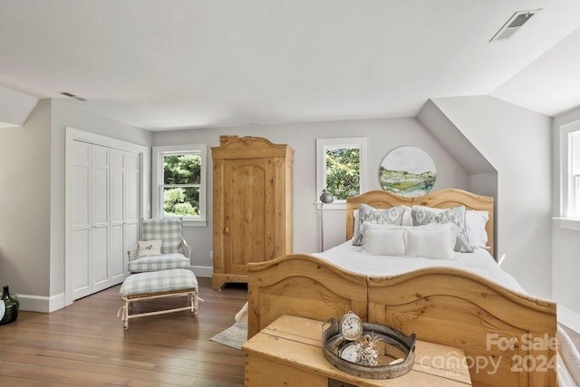 bedroom featuring vaulted ceiling, a closet, and hardwood / wood-style flooring