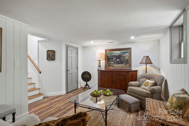 living room featuring hardwood / wood-style floors and wooden walls