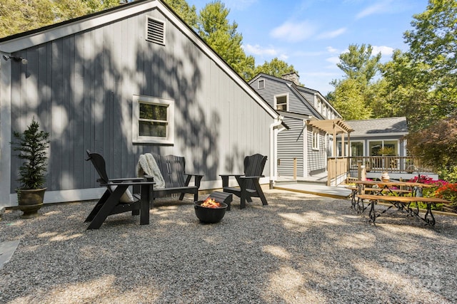 exterior space with an outdoor fire pit and a wooden deck