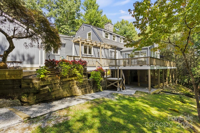 back of property featuring a wooden deck, a yard, and a patio