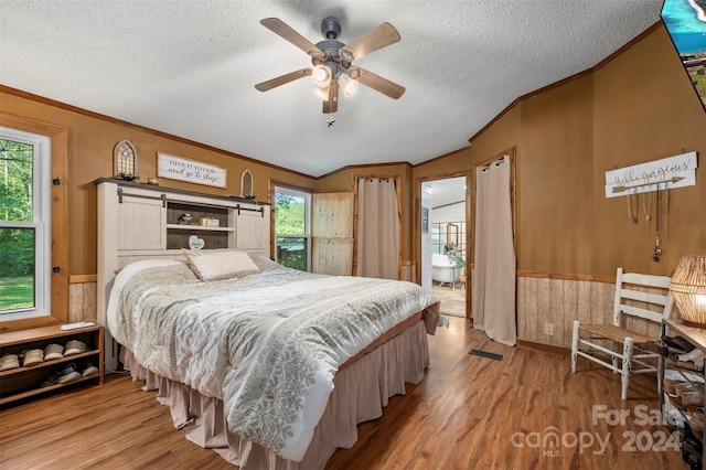 bedroom featuring multiple windows, ceiling fan, light hardwood / wood-style floors, and a textured ceiling