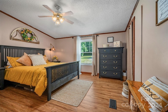 bedroom with a textured ceiling, crown molding, ceiling fan, and hardwood / wood-style floors